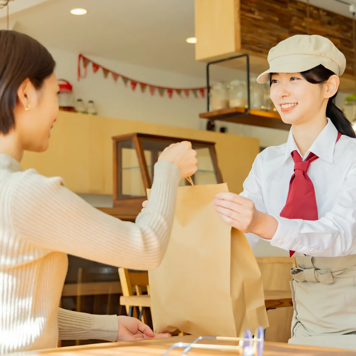 定員がお客様に商品を渡す様子の写真